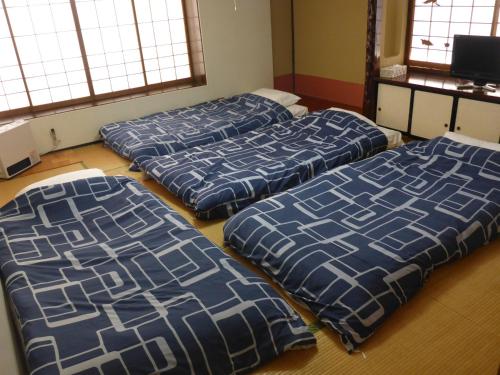 a room with four beds sitting on the floor at Nozawa Dream in Nozawa Onsen