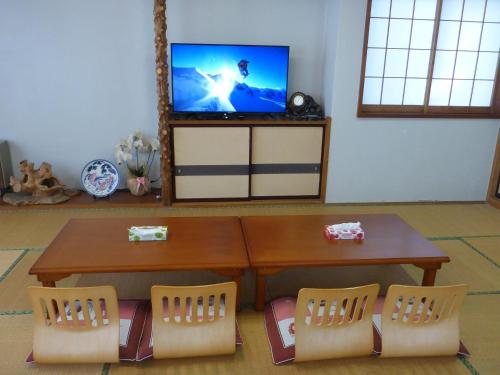 a living room with a table and two chairs and a tv at Nozawa Dream in Nozawa Onsen