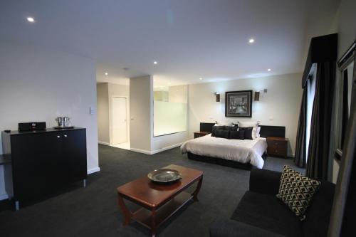 een grote hotelkamer met een bed en een tafel bij Hogans Motel in Wallan