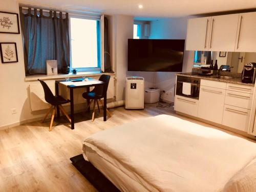 a bedroom with a bed and a table and a kitchen at Top city center location by Airhome in Zug