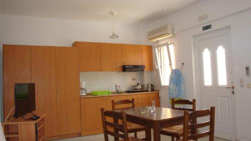 a kitchen with a table and a tv in a room at Calamon Apartments in Episkopí- Rethimno