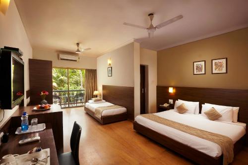 a hotel room with a bed and a desk and a room at The Hawaii Comforts in Panaji