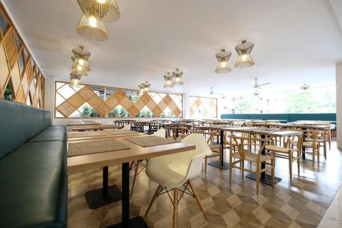 a restaurant with wooden tables and chairs and windows at Sunday Wongamat Privacy Pattaya in North Pattaya