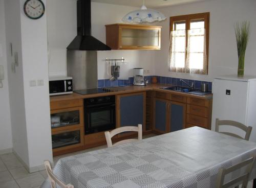 cocina con mesa, nevera y fogones en Joli T2 1er etage ancienne bergerie en La Seyne-sur-Mer