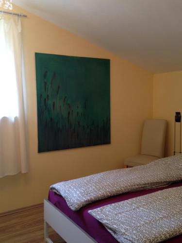 een slaapkamer met een bed en een schilderij aan de muur bij Künstlerhäuschen in Oberwesel