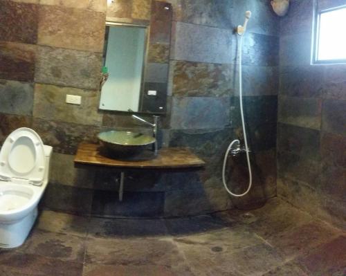 a bathroom with a toilet and a sink and a shower at Bright Moon Homestay in Dongshi
