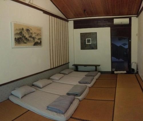 a room with four beds lined up in a row at Bright Moon Homestay in Dongshi