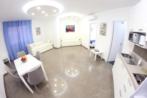 a kitchen with a table and chairs and a room with a sink at Mondo Suites Apartments in Naples