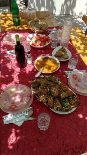a table with plates of food and a bottle of wine at Apartment Milena in Virpazar