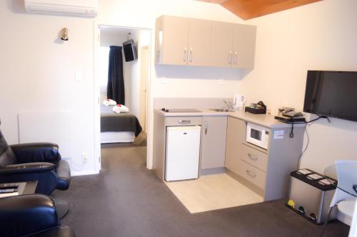 a small room with a kitchen and a bed at Aspen on King in Timaru