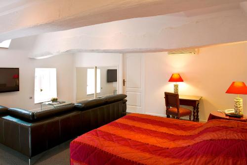 a bedroom with a bed and a couch and a desk at Château de Fleurville & Spa in Fleurville