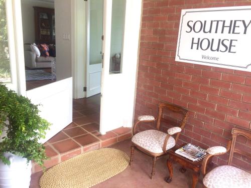 a porch with two chairs and a sign that reads southern house at Southey House in Kloof