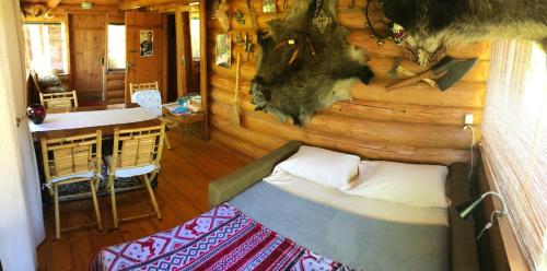 1 dormitorio con 1 cama en una cabaña de madera en Usadba 4 Seasons, en Bogino
