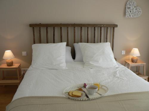 een dienblad met brood en koffie op een bed bij La Mariennaye in Beaurepaire