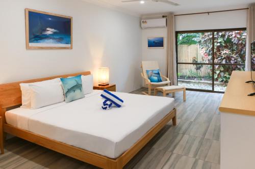 a bedroom with a bed and a large window at Birch Resort Port Douglas in Port Douglas