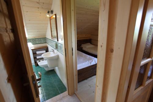 La petite salle de bains est pourvue de toilettes et d'un lavabo. dans l'établissement Apartamenty Osowa nad jeziorem Okmin, à Suwałki