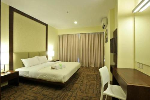 a hotel room with a bed and a desk at Hotel Primera Suite Cyberjaya in Cyberjaya