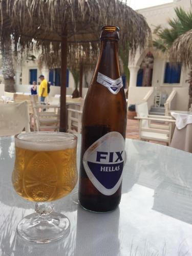 a bottle of beer sitting on a table next to a glass at The Boathouse Hotel in Kamari
