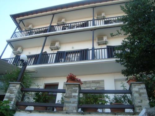 a large building with a balcony on top of it at Hotel Sevilli in Agios Ioannis Pelio