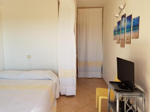 a bedroom with a bed and a desk with a computer at Lulamax Sardegna in Budoni