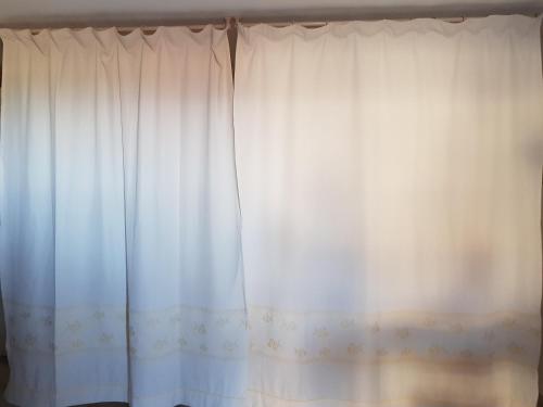 a white curtain is hanging in a bedroom at Lulamax Sardegna in Budoni