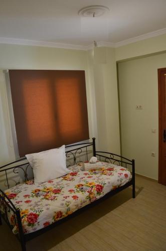 a bedroom with a bed with a floral blanket at ESTIA V.M in Ýpsos