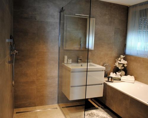 Un baño con ducha, lavabo y bañera. en B&B Elegance Hamont, en Hamont