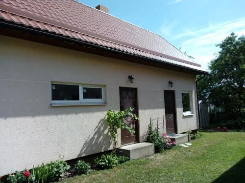 a white house with a window and a door at Holiday home in Ogre