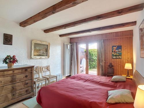 een slaapkamer met een rood bed en een dressoir bij Boucanier 002, appartement avec jardin in Verbier