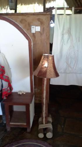 a lamp sitting next to a table and a chair at Bahari Pori Resort in Pangani