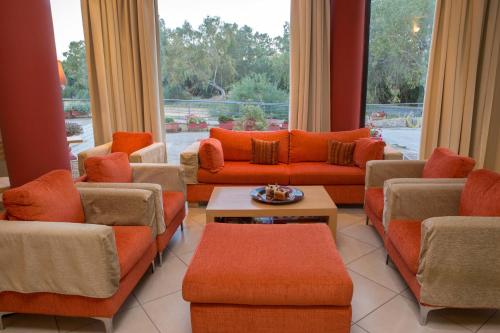 a living room with orange furniture and a large window at Aeolian Gaea Hotel in Skala Kallonis