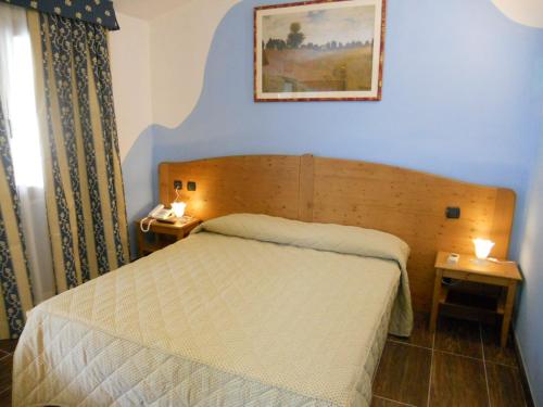 um pequeno quarto com uma cama e duas mesas de cabeceira em Hotel Sonno D'Autore em Borghetto di Vara
