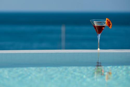 a glass of wine sitting next to a swimming pool at Hotel Helvetia in Sestri Levante