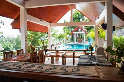 a patio with a table and chairs and a pool at Krabi Villa Phu Khao Private Resort in Klong Muang Beach