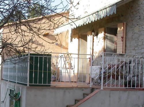 un chien assis sur la terrasse couverte d'une maison dans l'établissement Joli T2 RDC ancienne bergerie, à La Seyne-sur-Mer