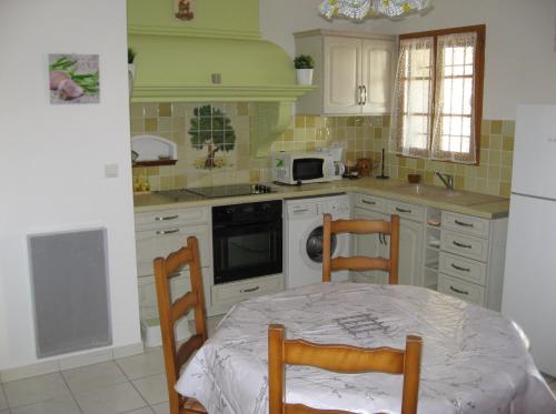 - une cuisine avec une table et deux chaises dans l'établissement Joli T2 RDC ancienne bergerie, à La Seyne-sur-Mer