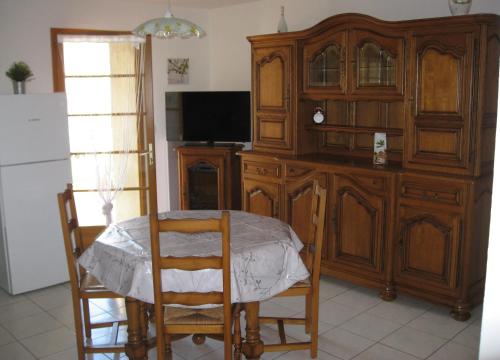 uma sala de jantar com uma mesa e um grande armário de madeira em Joli T2 RDC ancienne bergerie em La Seyne-sur-Mer