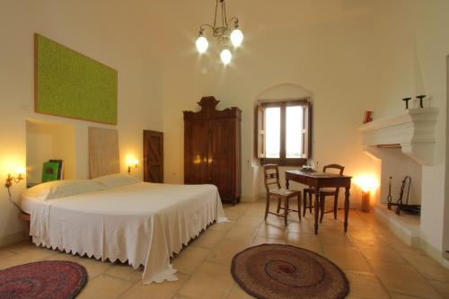 a bedroom with a bed and a table and a desk at Agriturismo Masseria Gianferrante in Ugento
