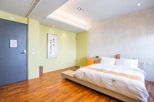 a bedroom with a large bed and a wooden floor at WMS Villa in Dongshan