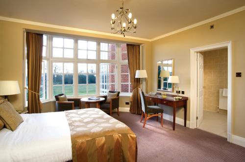a hotel room with a bed and a desk and a bedroom at Grovefield House Hotel in Slough