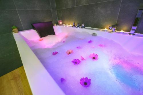 a bathtub covered in pink dye with flowers in it at Casa Rural Aguas Frias II in La Omañuela