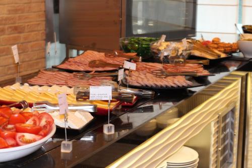 een buffet met veel verschillende soorten eten bij Aparthotel Marina Holiday Club - All Inclusive & Free Parking in Pomorie