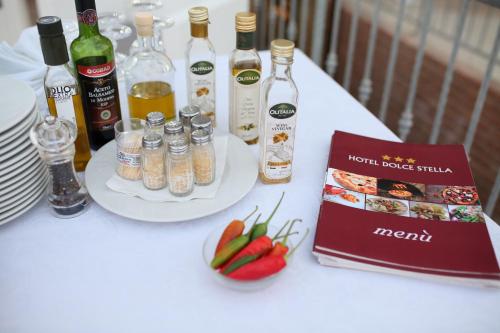 a white table with bottles of wine and a book at Hotel Dolce Stella in Torre Melissa