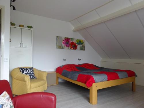 een slaapkamer met een bed en een stoel bij B&B Mendelts in Emmen