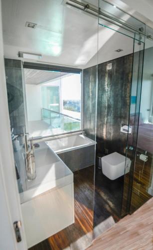 a bathroom with a sink and a glass shower at Palmares Beach, Golf & Dream in Lagos