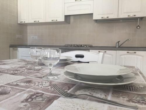 a kitchen with a table with plates and wine glasses at Alex Apartment Pula in Pula