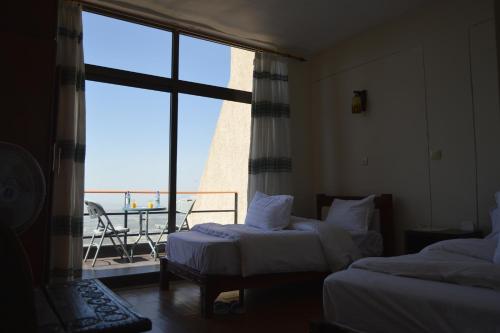 a hotel room with two beds and a large window at Panoramic View Hotel in Lalībela