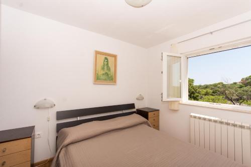 ein Schlafzimmer mit einem Bett und einem Fenster in der Unterkunft Apartments Vukman in Trogir