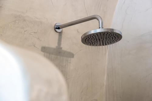 a shower with water pouring from a shower head at Adamant Suites in Fira