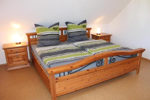 sypialnia z drewnianym łóżkiem i 2 szafkami nocnymi w obiekcie Ferienwohnung Faber mit großem Südbalkon w mieście Essing